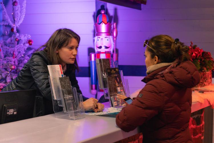 Accueil 1850 - Une personne de l'office de tourisme conseille une vacancière
