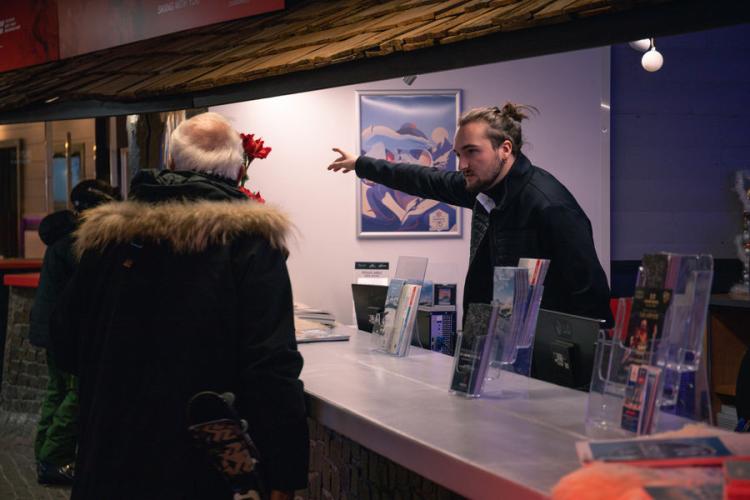 Accueil 1850 - Une personne de l'office de tourisme conseille un vacancier
